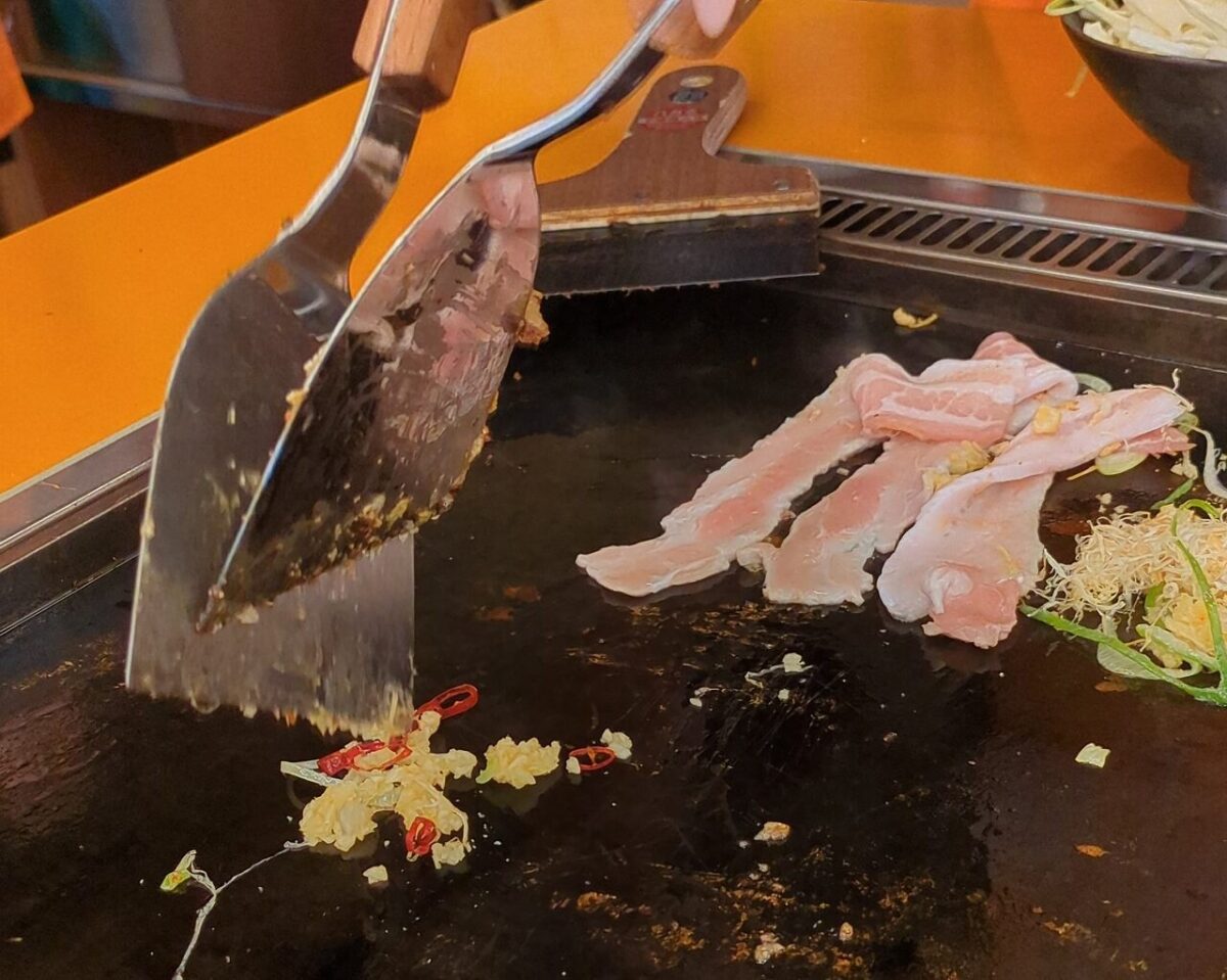 月島もんじゃたまとや綱島の豚ネギ塩もんじゃ焼いているところ