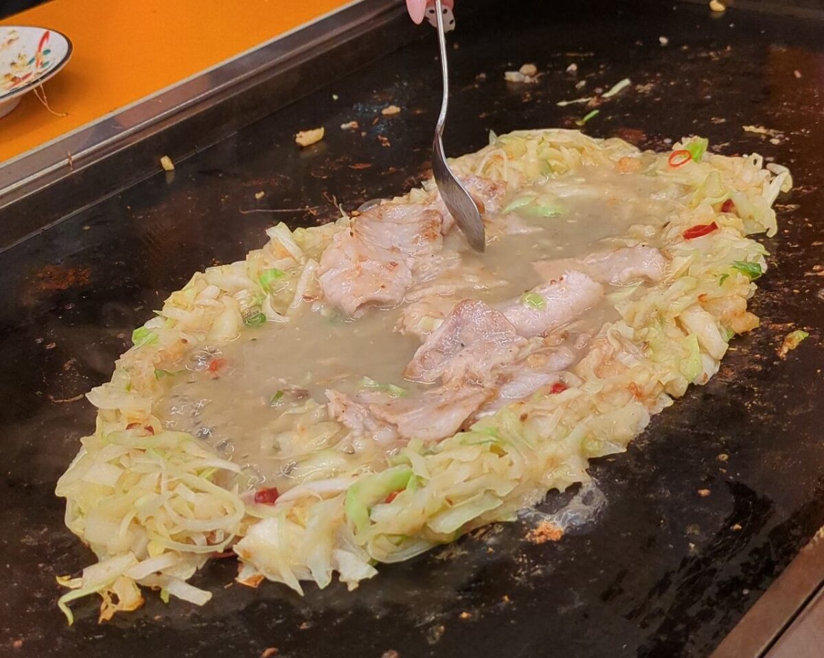 月島もんじゃたまとや綱島の豚ネギ塩もんじゃ焼いているところ