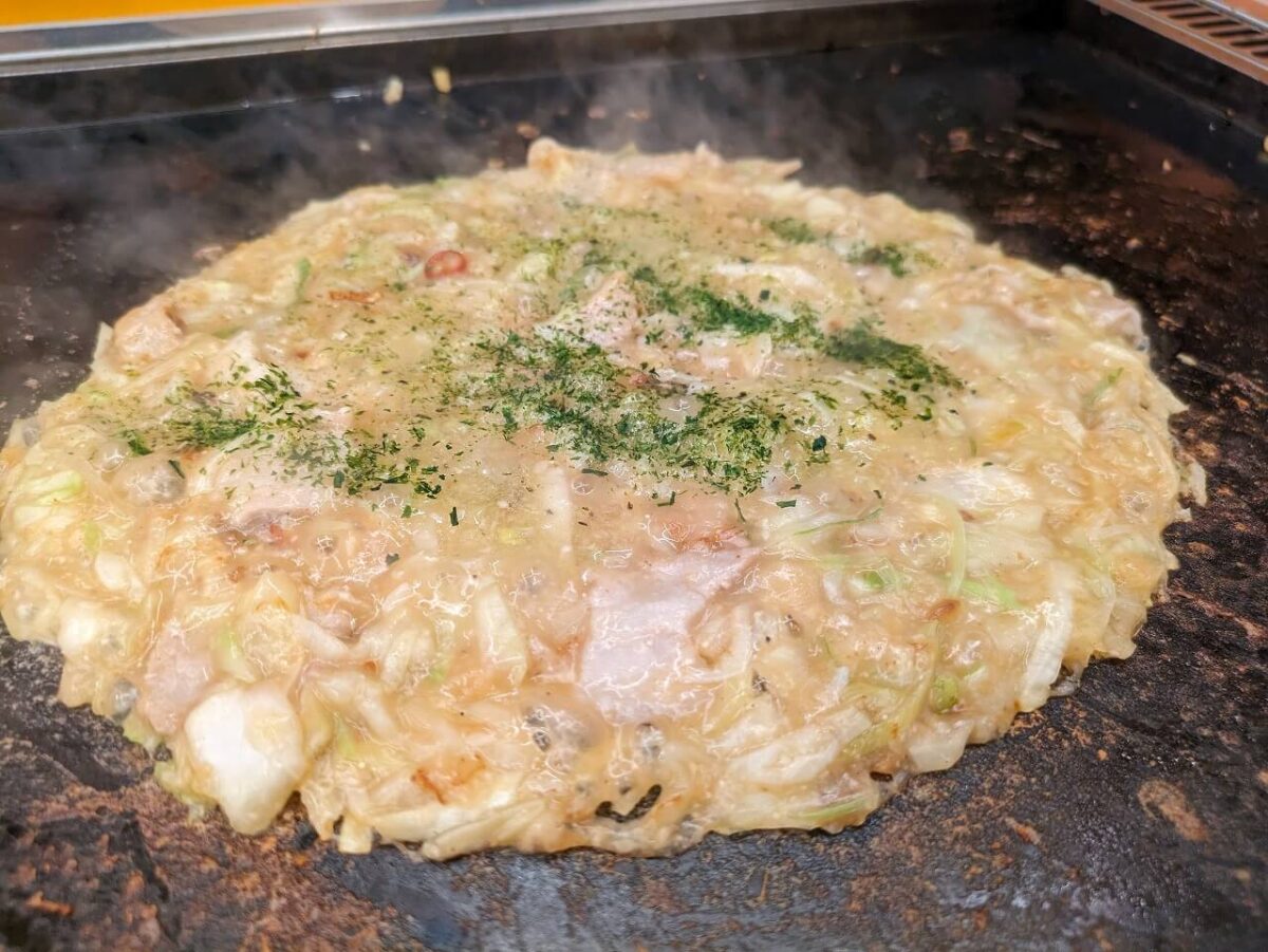 月島もんじゃたまとや綱島の豚ネギ塩もんじゃ焼いているところ