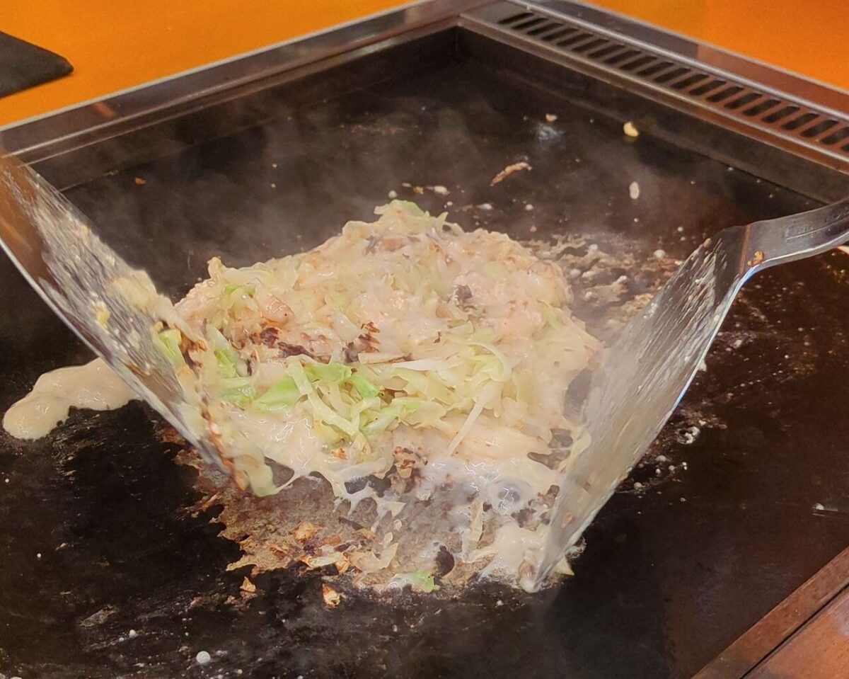 月島もんじゃたまとや綱島の明太もちもんじゃ焼いているところ